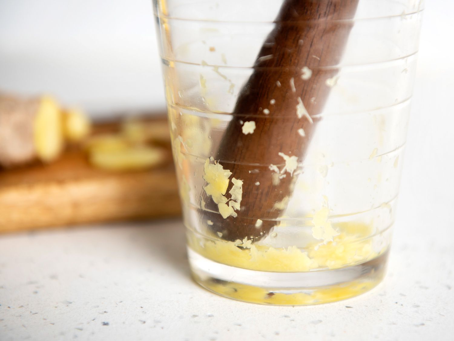 muddling ginger in a glass