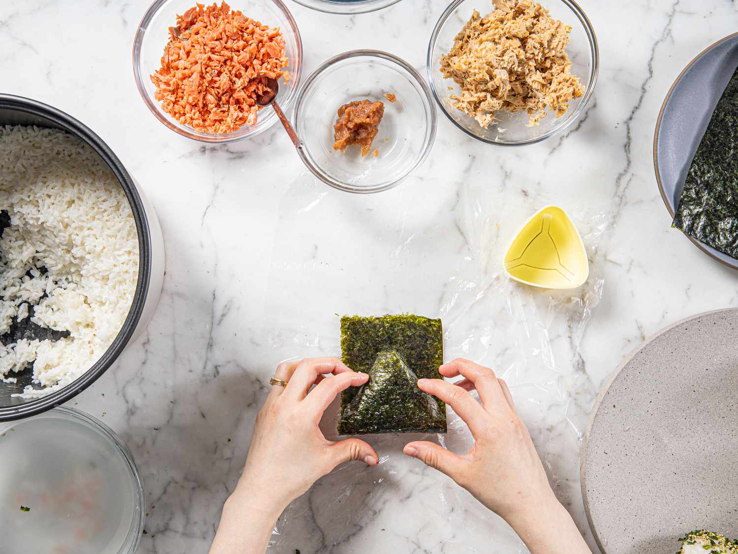 Overhead image of folding onigiri in seaweed