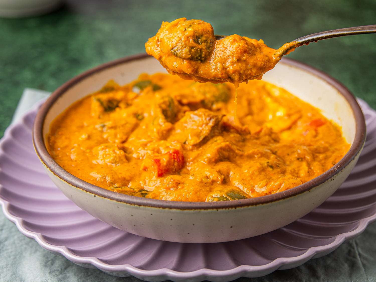 Bowl of Nigerian egg sauce with a spoon lifting a portion