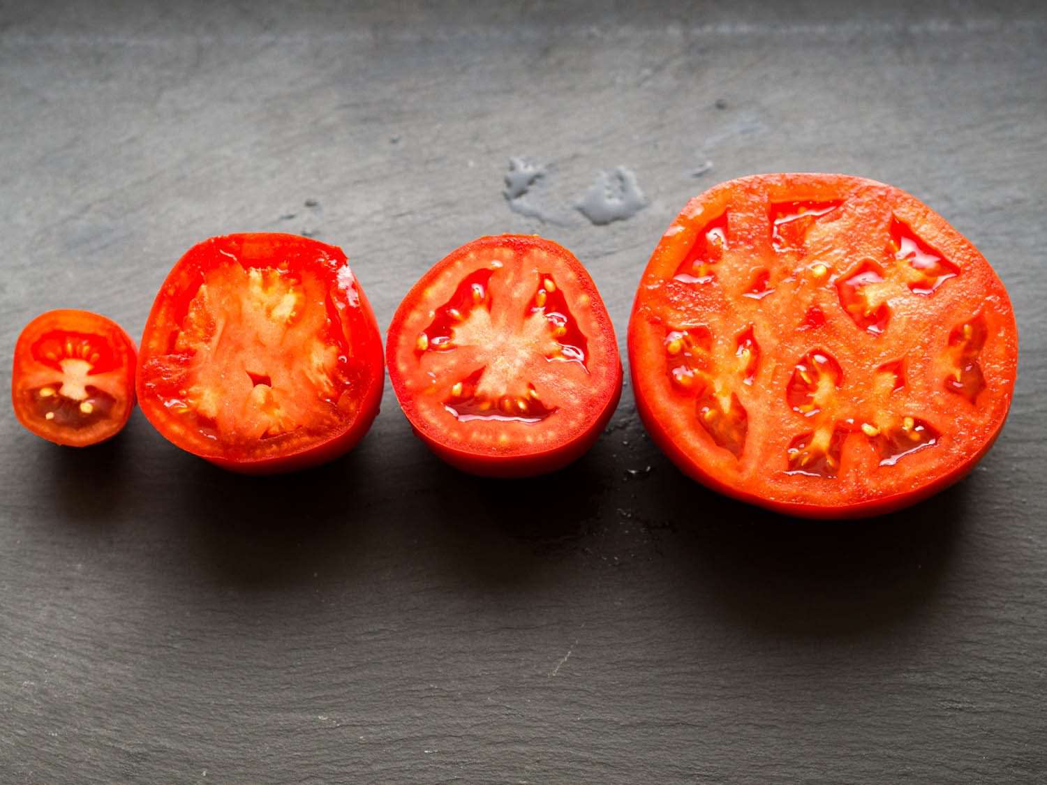 Different varieties of tomatoes cut in half, cut sides facing up