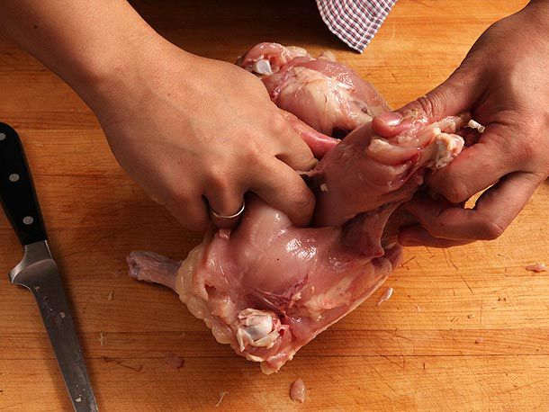 Separating breast meat from breast bone with index and middle fingers