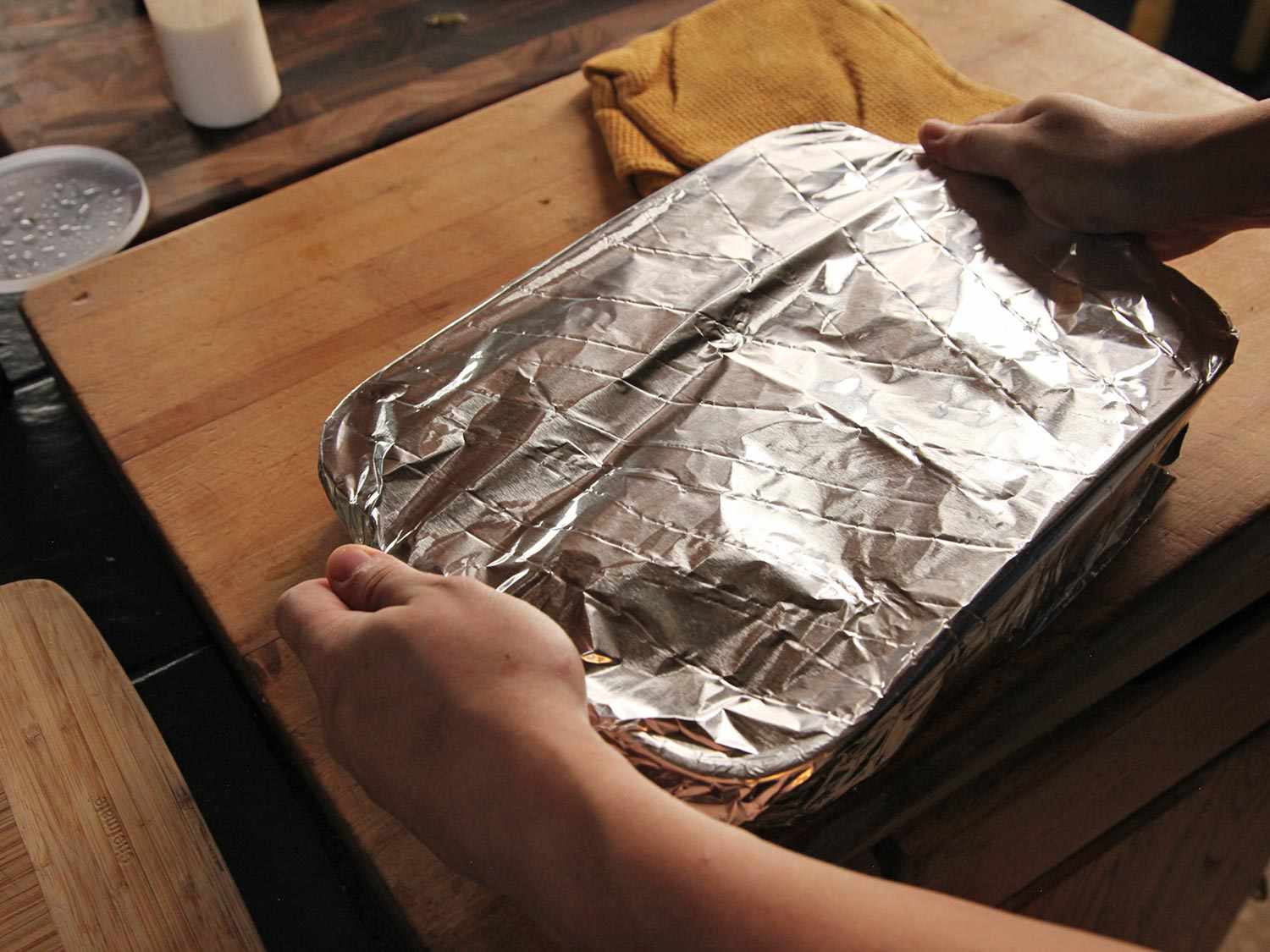 The baking dish of enchiladas is covered with foil.