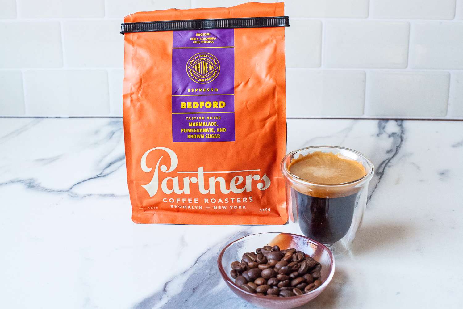Coffee beans, brewed coffee, and a bag of Partners Coffee Roasters Bedford blend