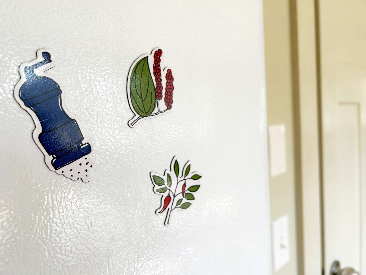 Three magnets on the side of a fridge.