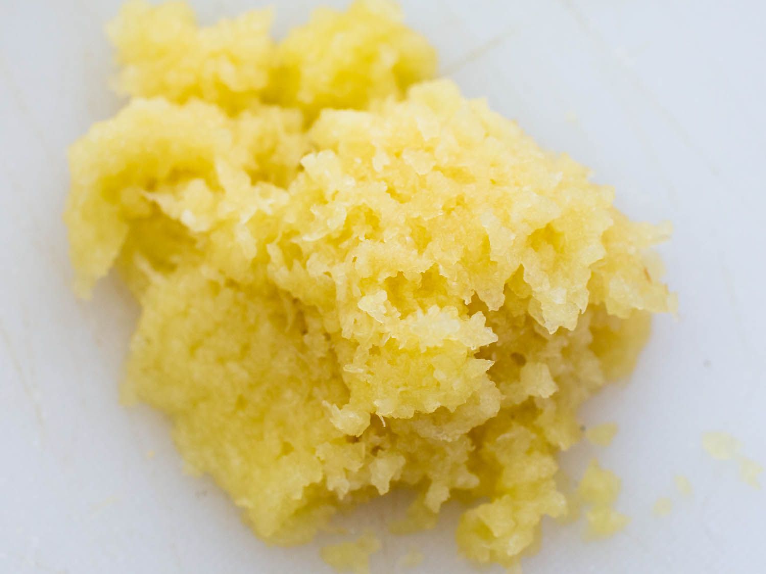 A pile of microplaned garlic that has been grated very, very fine.