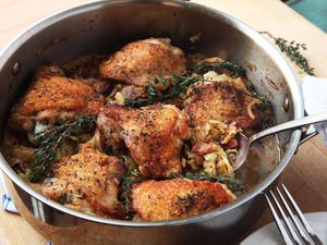 braised chicken thighs in a stainless steel saute pan