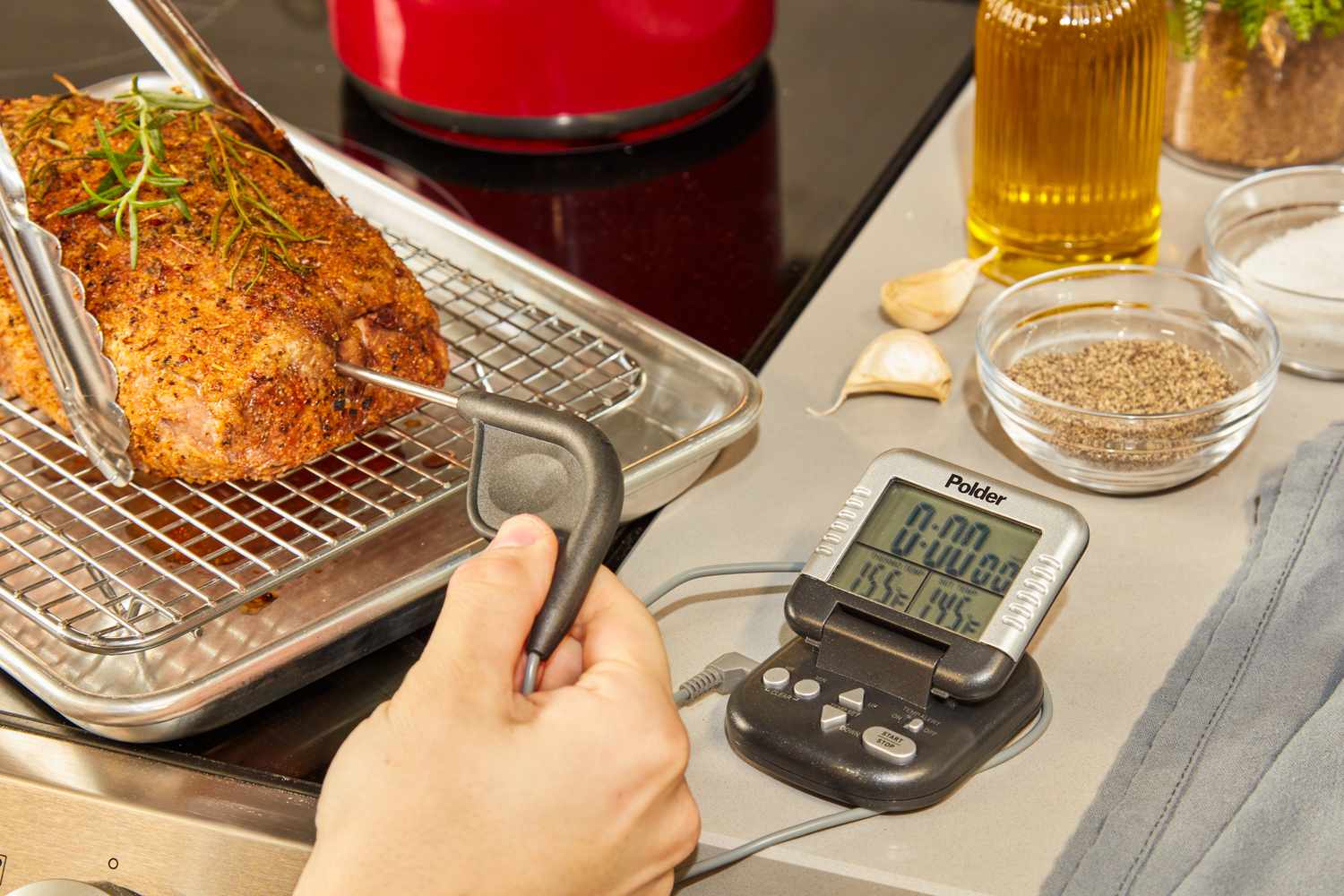 A person inserting a probe thermometer's probe into a roast.