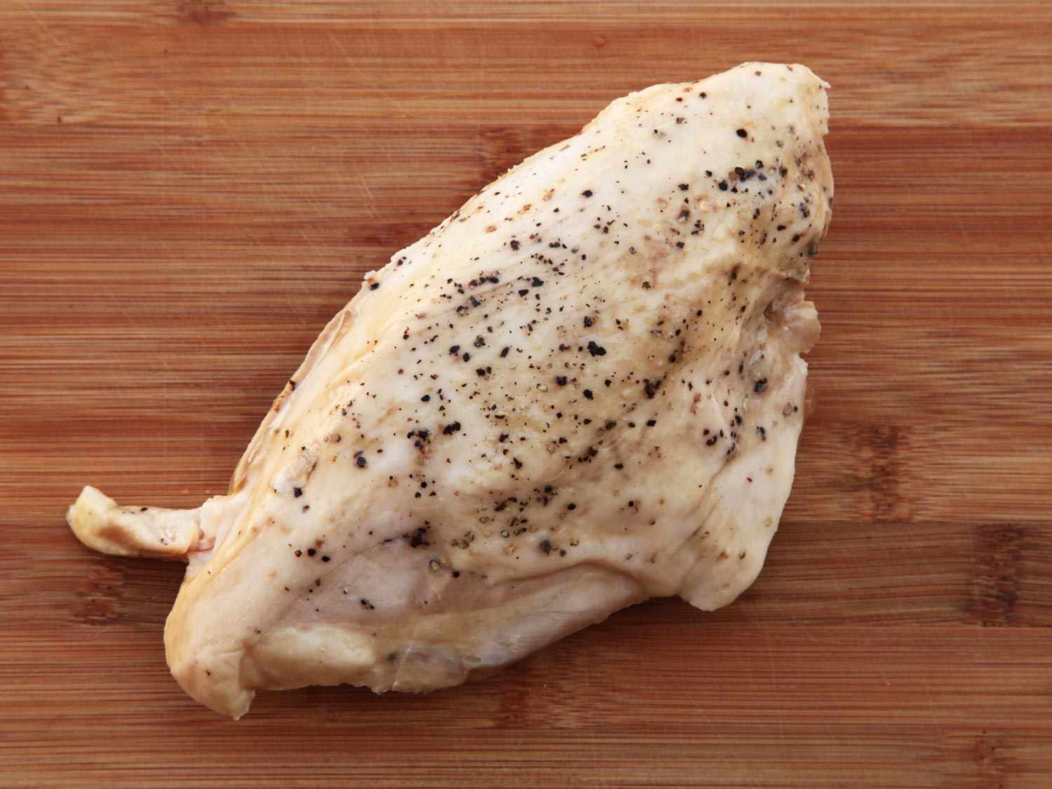 A sous vide chicken breast on a wooden surface.
