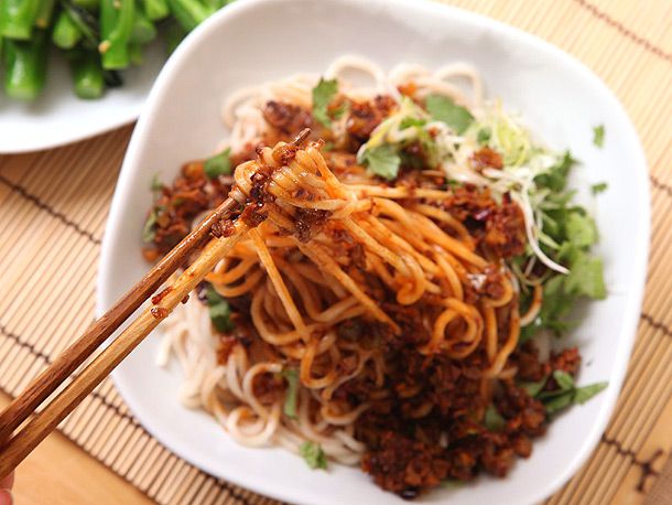 Using chopsticks to take a bite of vegan dan dan noodles.