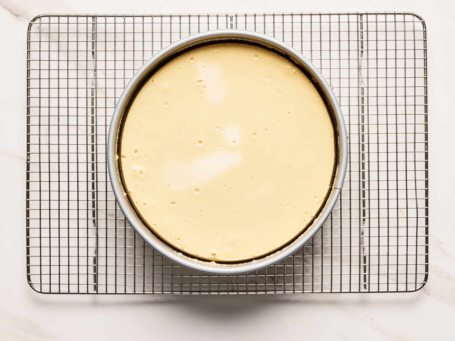 Baked cheesecake cooling on a wire rack