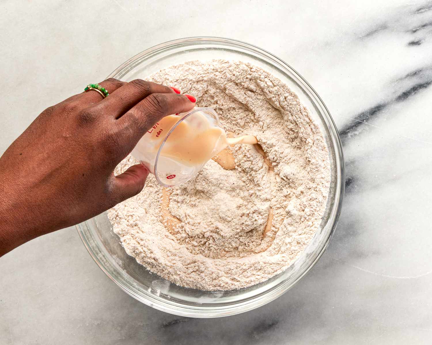 Pouring brine ingredients into dry ingredients for fried chicken