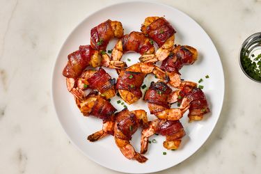 Cooked shrimp on a white plate on a marble surface 