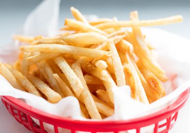 McDonald's-style thin and crispy french fries in plastic basket.