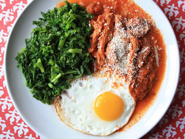A plate of trippa alla romana served with greens and a fried egg. 