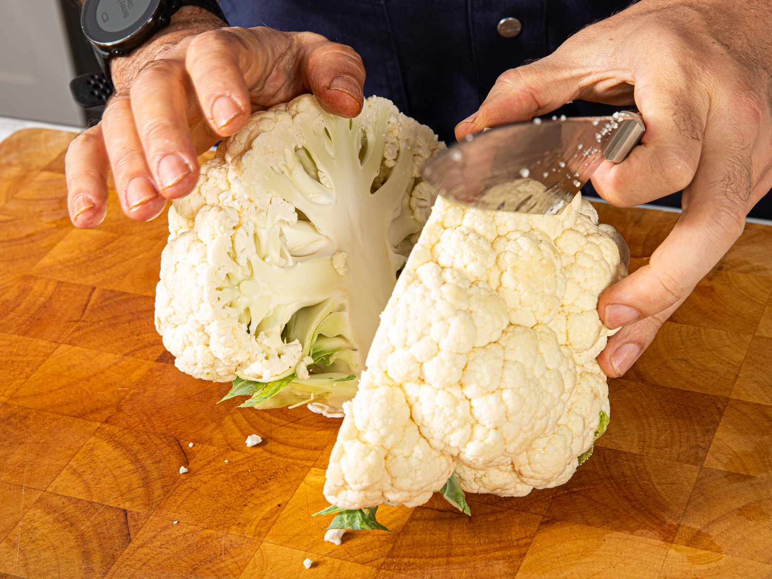 Overhead view of cutting a cauliflower in half