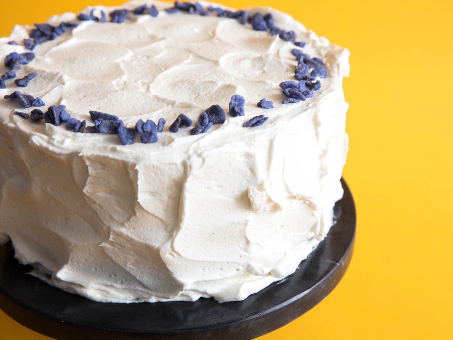 Chiffon cake baked in round layer cake pans frosted and decorated with dried lavender. 
