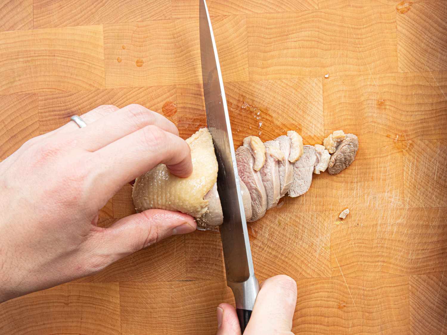 Overhead view of cutting duck meat
