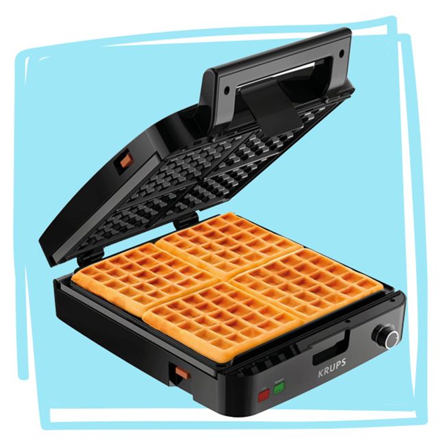 Open Belgian waffle maker with cooked waffles visible