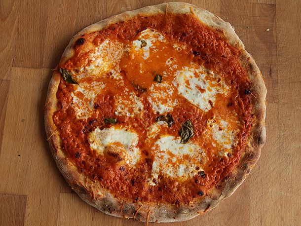 A vodka sauce pizza on a wooden surface.