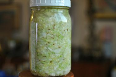 Profile view of a quart-size canning jar filled with sauerkraut.
