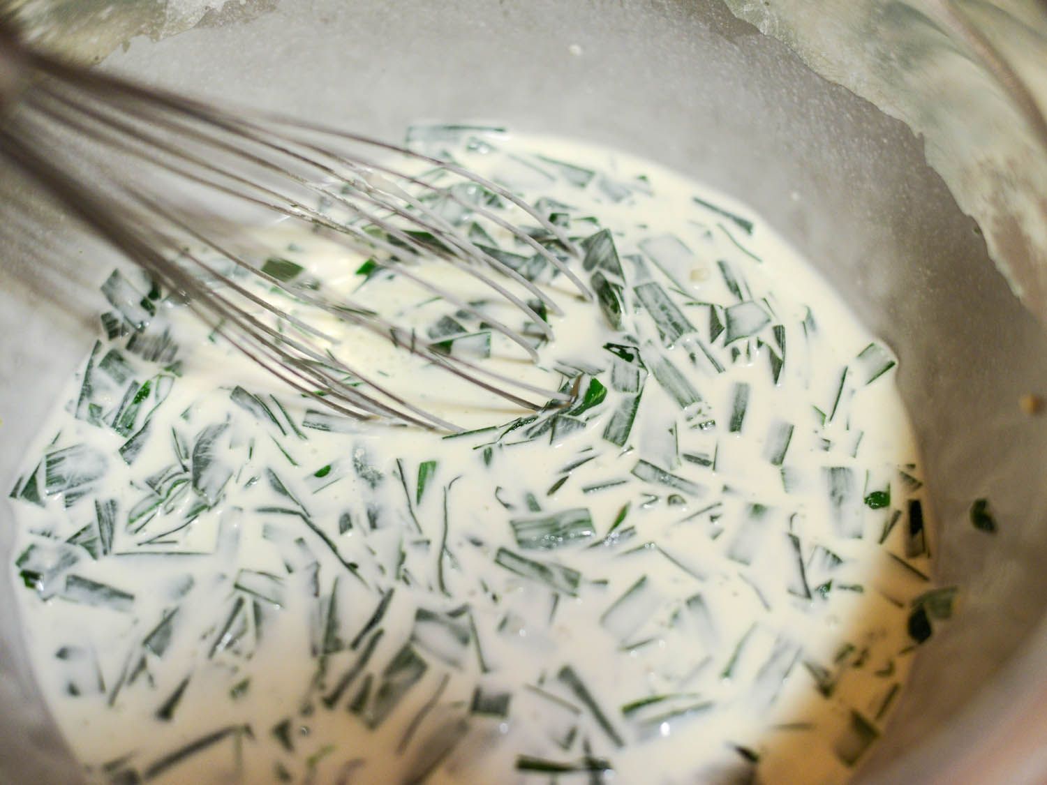 Whisking the chives into the batter for rice cakes.