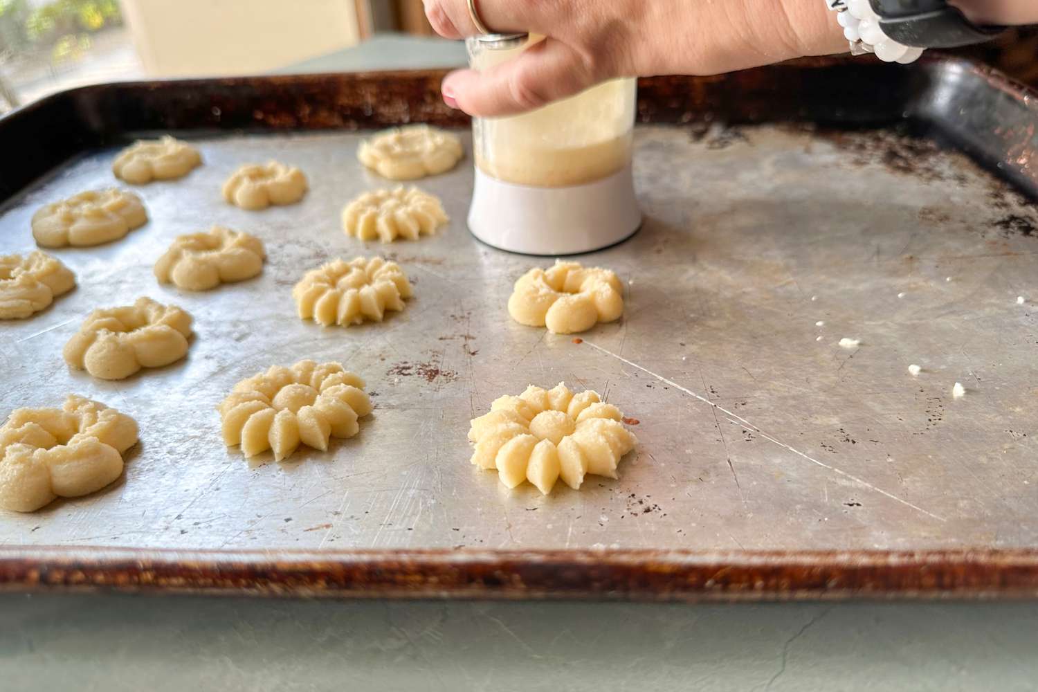 A person making cookies using the OXO Good Grips Cookie Press