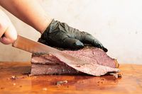 A person slicing meat using the Wusthof Classic Carving Knife