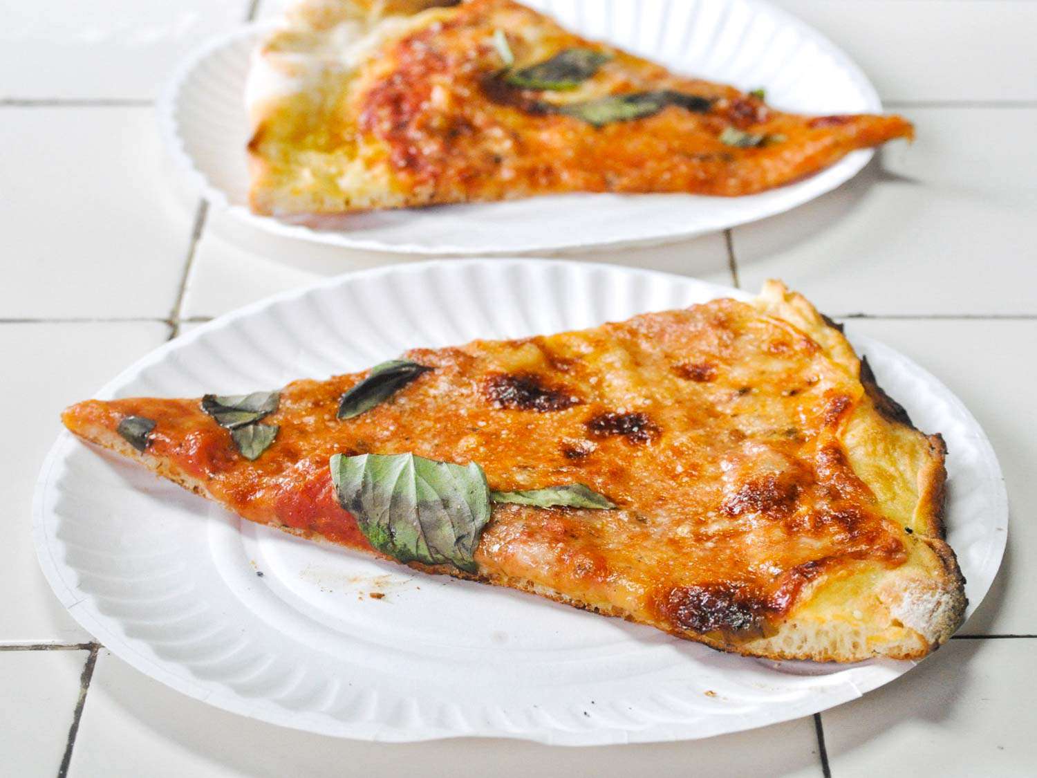 Cheese slices on paper plates from Di Fara