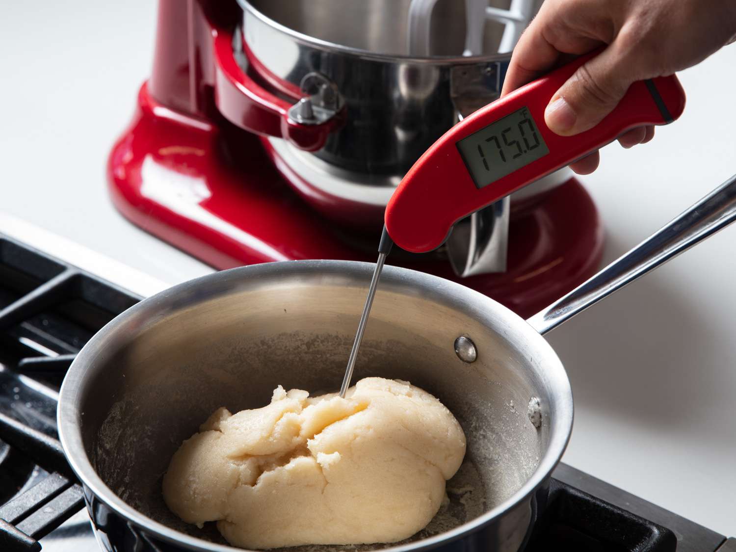 checking the temperature of the choux panade with a thermometer