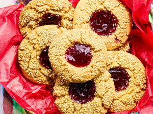 Thumbprint cookies with seeds and jam filling on red wrapping paper