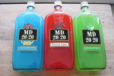 Three bottles of MD 20/20 next to each other: blue raspberry, dragon fruit, and kiwi-lemon. 