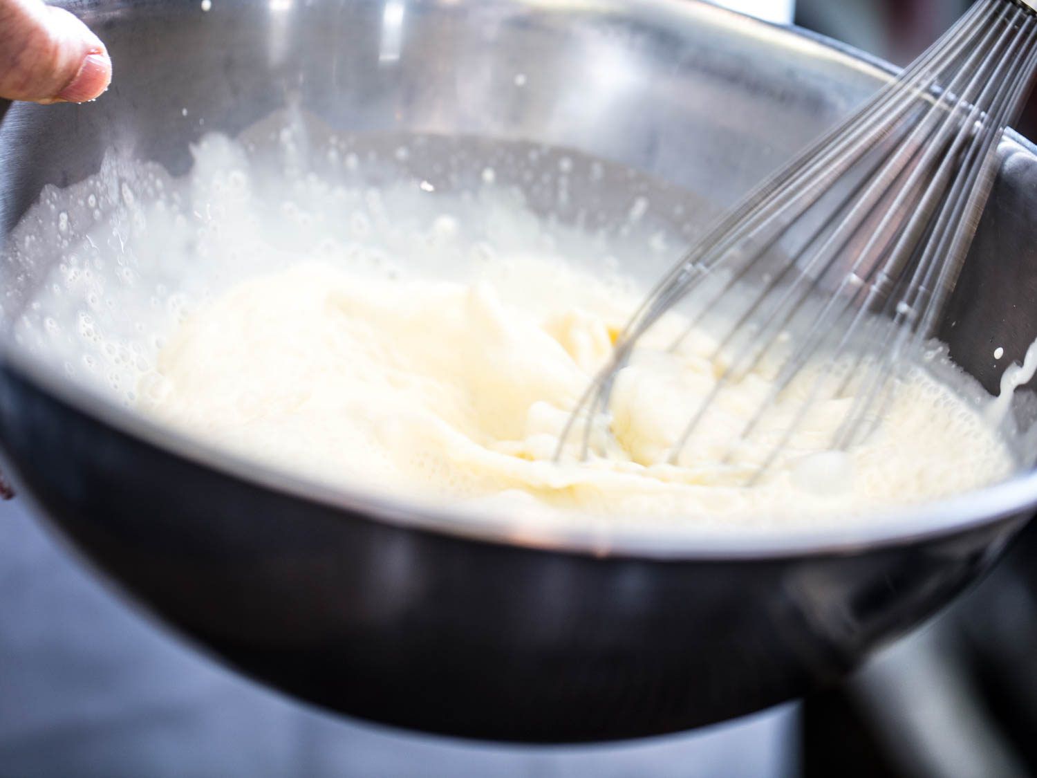 Whisking whisky cream in by hand in a mixing bowl. 