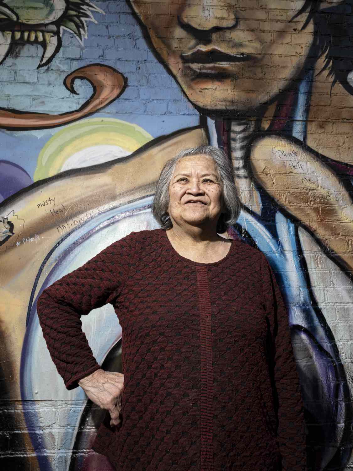 Tane Chan posing in front of a mural outside