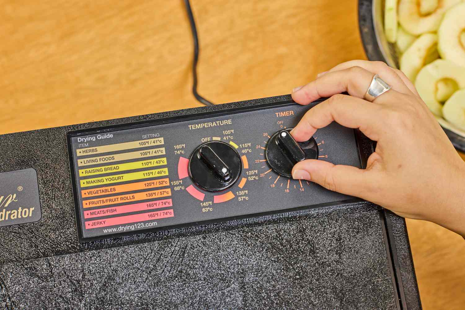 A person rotating the knob of Excalibur Electric Food Dehydrator Machine