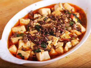 Mapo Tofu with ramps, served in a shallow, white, ovoid serving bowl.