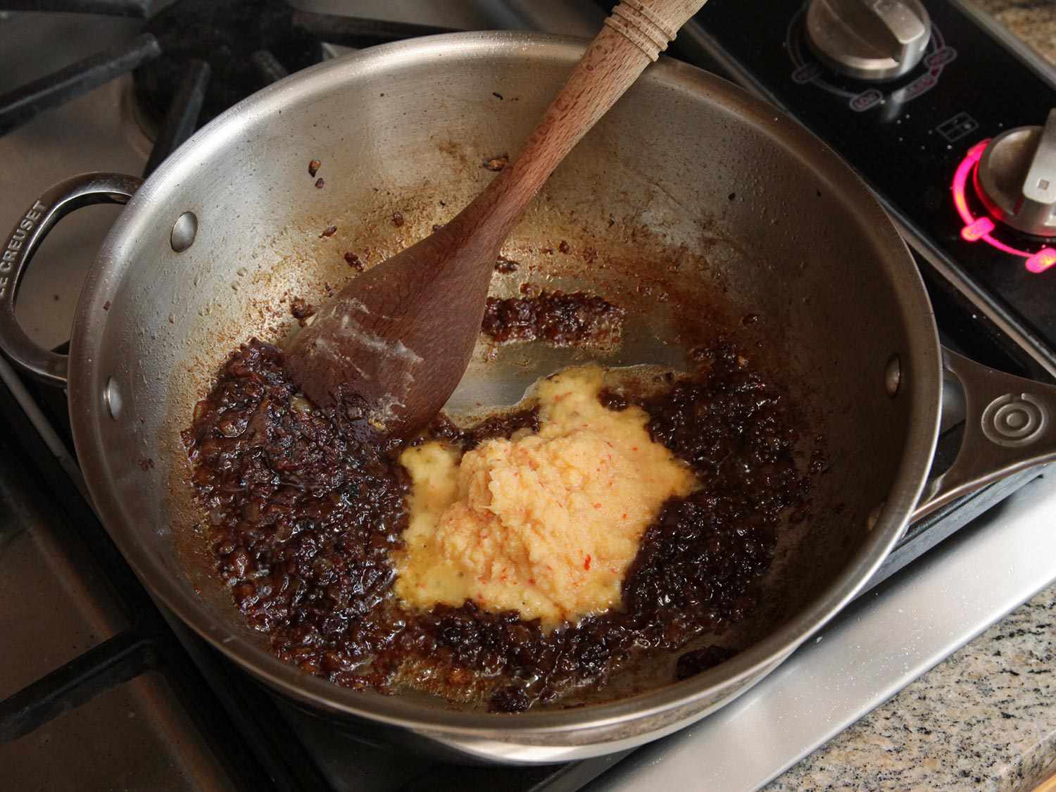 Garlic-ginger paste is added to the caramelized onions and spices.