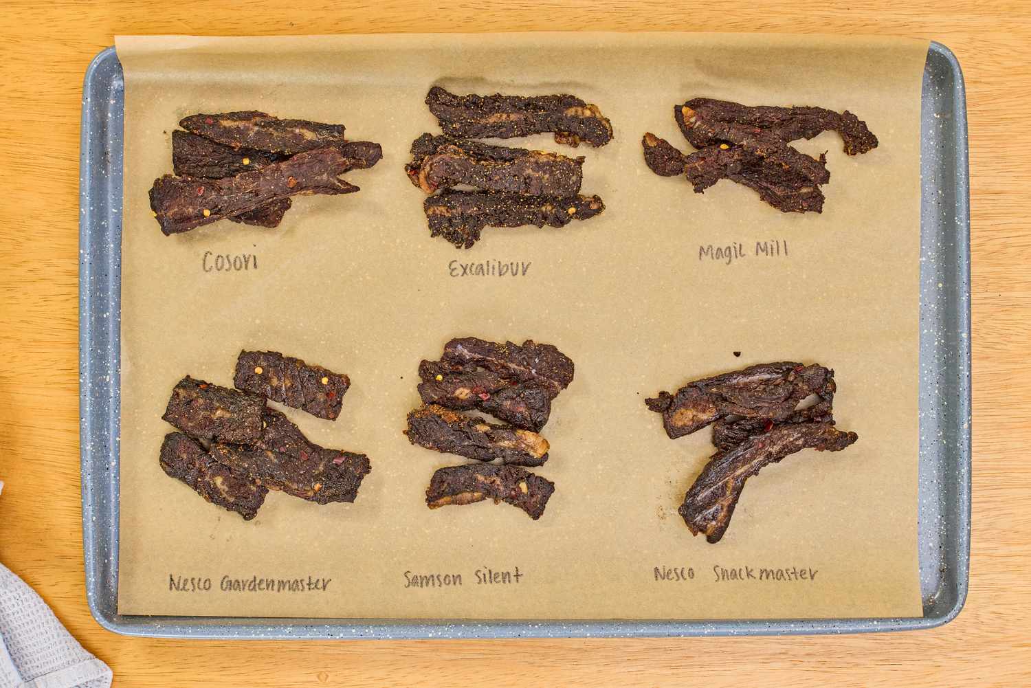 Beef jerky samples on a parchment-lined baking sheet