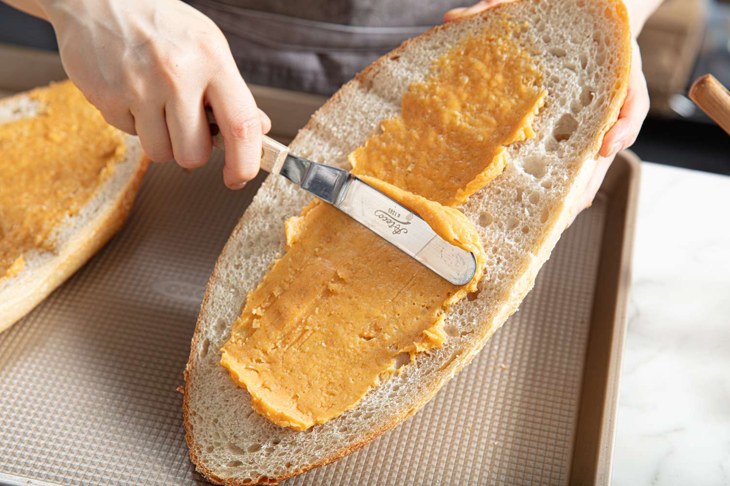 Overhead view of buttering garlic bread 