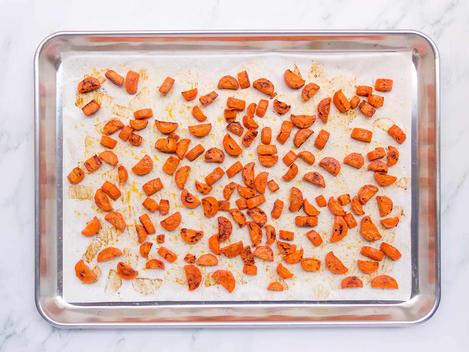 Carrots on a parchment-lined baking sheet.