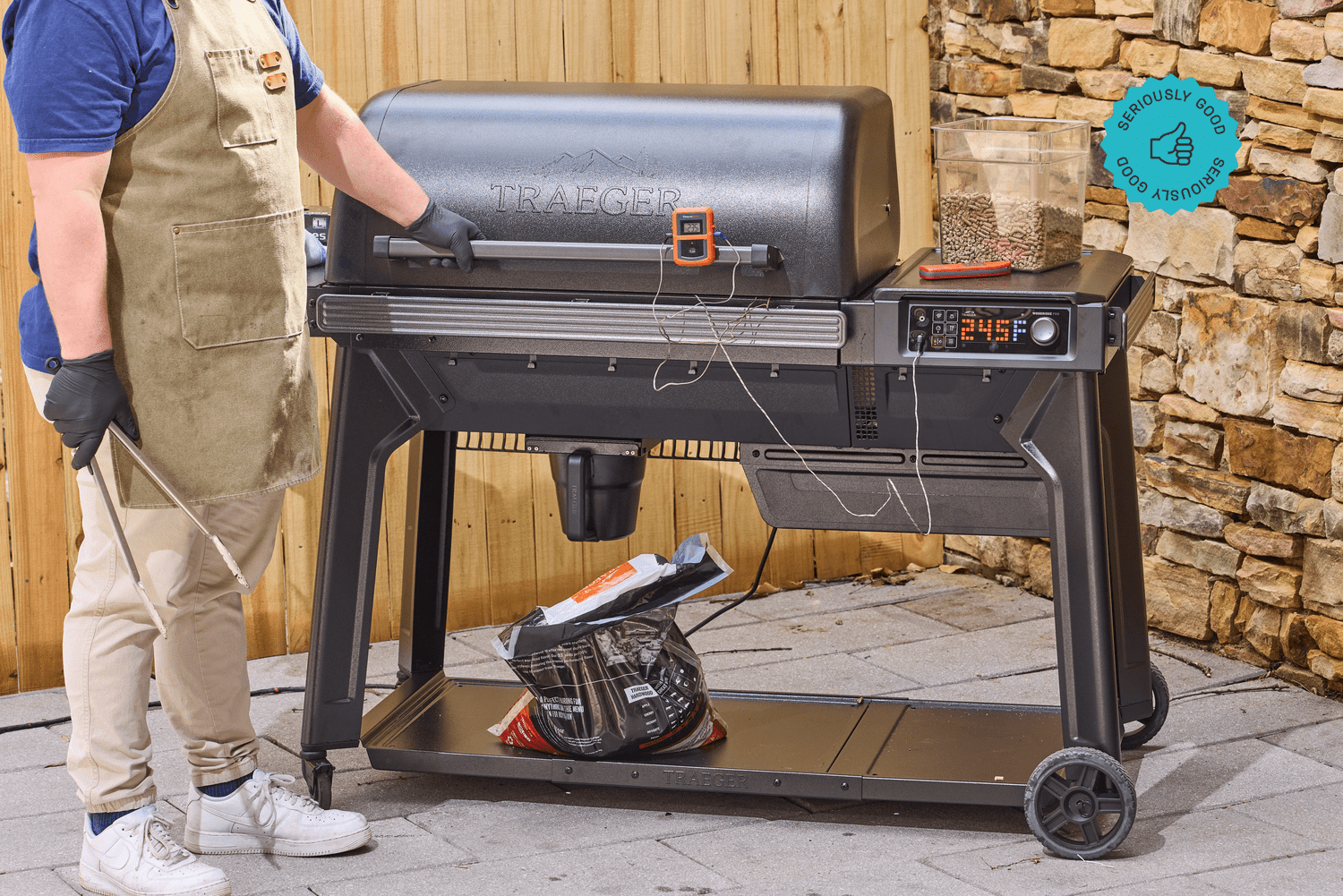 A person standing in front of the Traeger Woodridge pellet grill on a patio