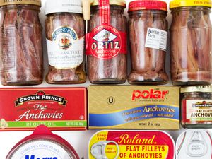 An assortment of cans and jars of anchovies. 