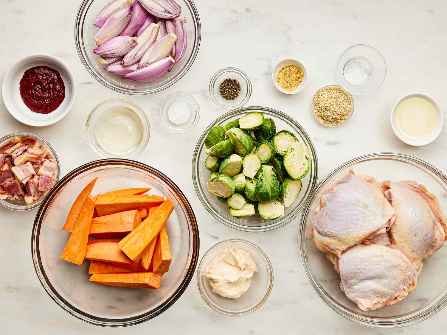 Mise in place of chicken, brussels, carrots, shallots, and herbs and cause 