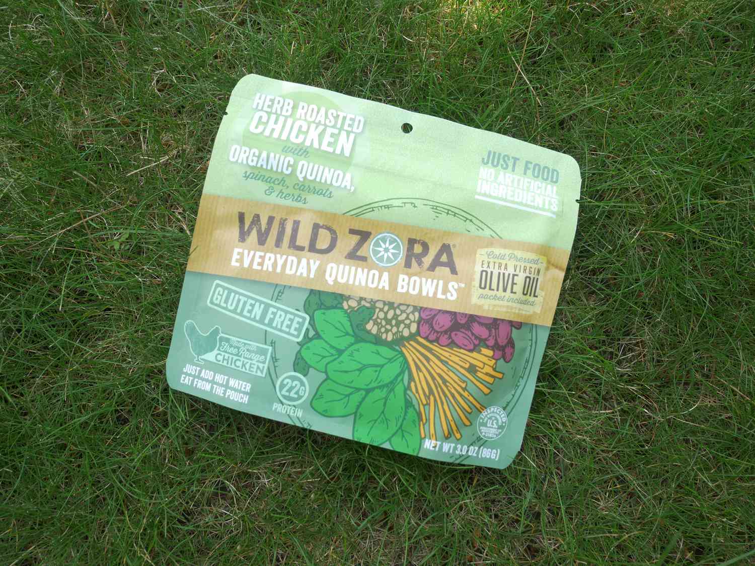 Wild Zora herb roasted chicken with quinoa packet on a lawn