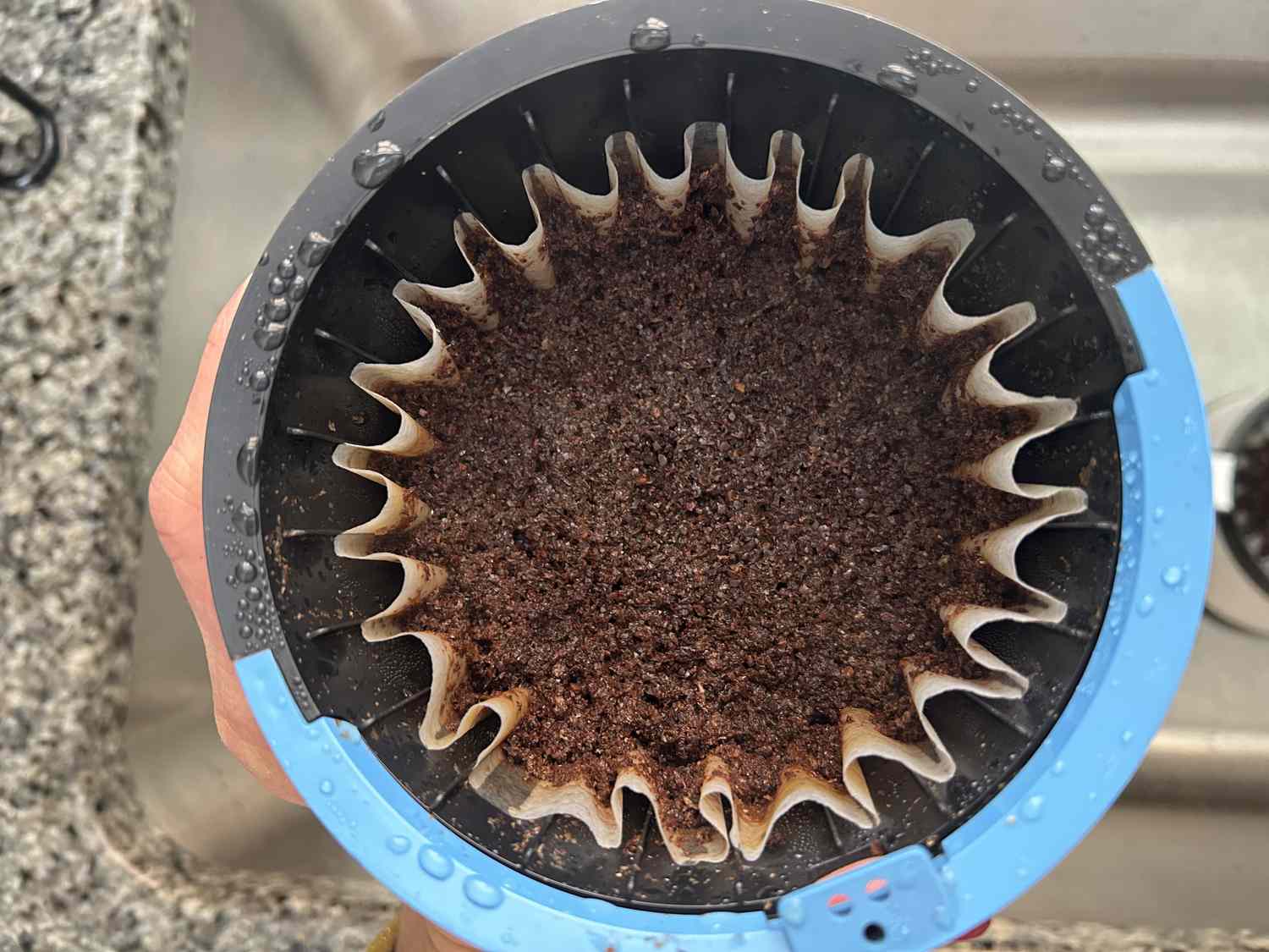 An overhead view of wet coffee grounds in a brew basket.