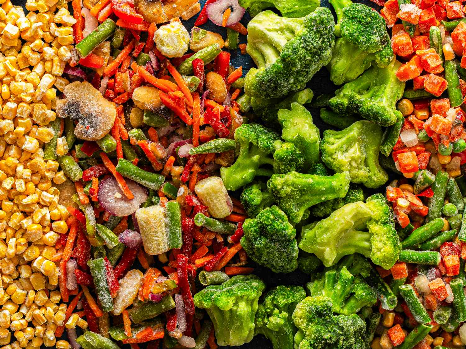 Assorted frozen vegetable pieces including broccoli corn and mixed vegetables arranged in bands