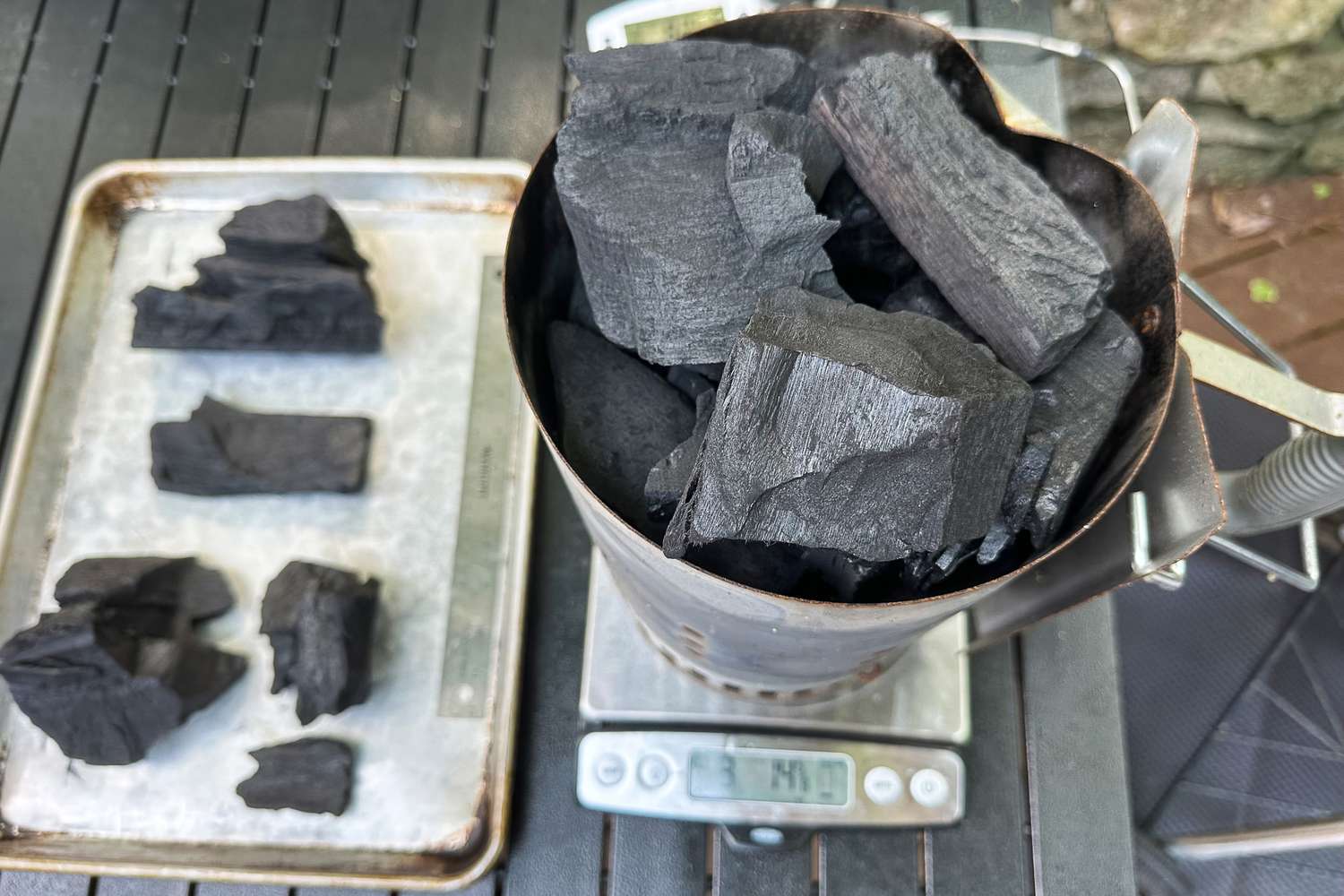Jealous Devil Chunx Lump Charcoal briquettes in a container on a digital scale and on a tray nearby