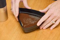 A person sifts ground coffee after grinding in the 1Zpresso J Manual Coffee Grinder