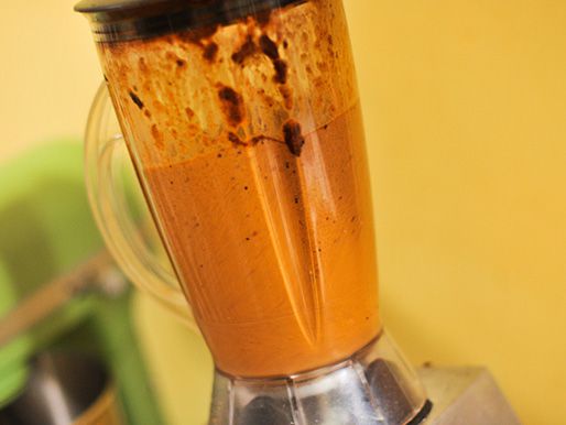 Chiles and spice mixture getting blended in a blender.