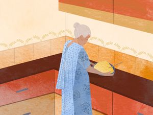 An illustration of Ajji in the kitchen, picking up a platter piled high with food.