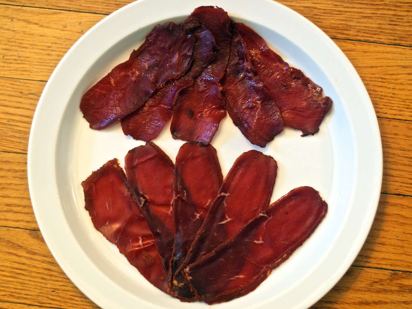 Overhead photo of Turkish-style pastırma on white serving plate.